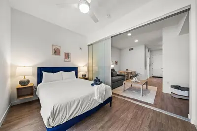 a bedroom with a large bed and a living room at Stylish City Escape Walk to Shops Dine & Explore in Long Beach