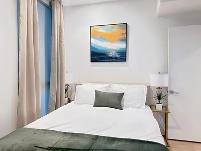 a bedroom with a bed and a painting on the wall at Luxury 2BD 2BA with Roof Top Pool, Hot Tub & Gym in Los Angeles