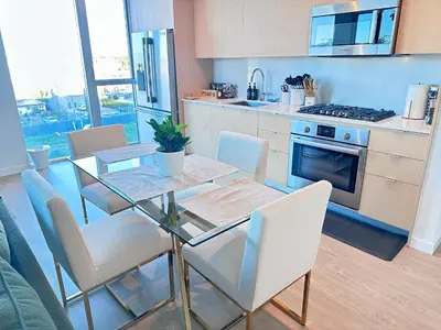 a kitchen with a glass table and chairs in a kitchen at Luxury 2BD 2BA with Roof Top Pool, Hot Tub & Gym in Los Angeles