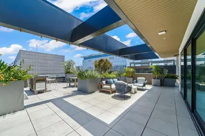a patio with furniture and plants on a building at Top-Floor Gem & Heated Pool Walk to Attractions in Long Beach