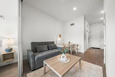 a living room with a couch and a table at Top-Floor Gem & Heated Pool Walk to Attractions in Long Beach