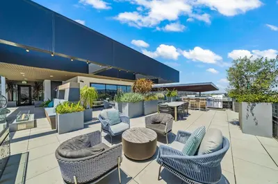 a patio with chairs and tables on a building at Top-Floor Gem & Heated Pool Walk to Attractions in Long Beach