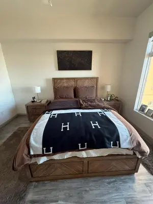 a bedroom with a large bed with a black comforter at Aqua Towers in Long Beach