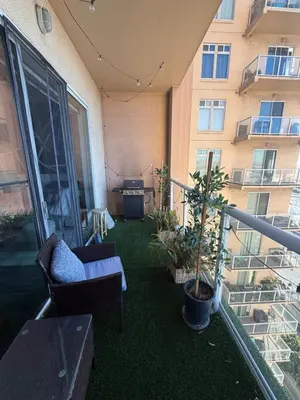 a balcony with a couch and a table and a building at Aqua Towers in Long Beach