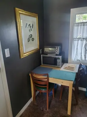 a small desk with a microwave and a table with a chair at Hidden Gem In Plain Sight in Van Nuys Airport