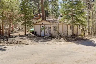 a small building in the middle of a forest at Cozy Forest Cottage w Lake Glimpse and Grill in Fawnskin