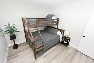 a bedroom with a bunk bed with a ladder at Family Friendly Southwest Bakersfield Retreat with Jacuzzi and Fenced Yard in Bakersfield