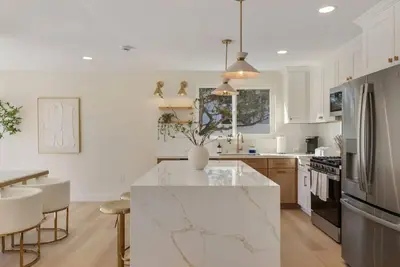 a kitchen with white cabinets and a marble counter top at Dream Dip - Heater Pool and Spa - Clost to Disney in Placentia