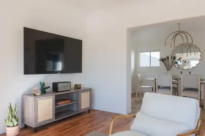 a living room with a tv on a white wall at University Hill Home With City Views, Hot Tub and 3 Parking Spots in Los Angeles