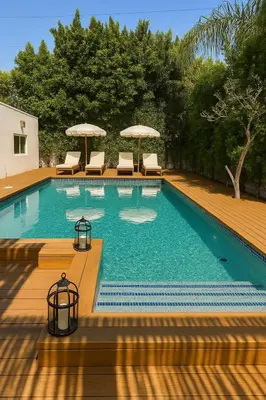a large swimming pool with chairs and umbrellas at WeHo Pool Retreat - Holiday Ready in Los Angeles