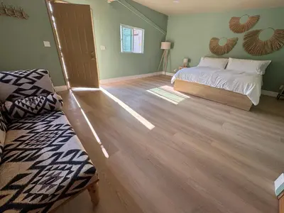 a bedroom with a bed and a wooden floor at WeHo Pool Retreat - Holiday Ready in Los Angeles