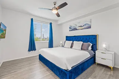 a bedroom with a blue bed and a window at Cozy 3 BR Apartment | Near Disney in Placentia