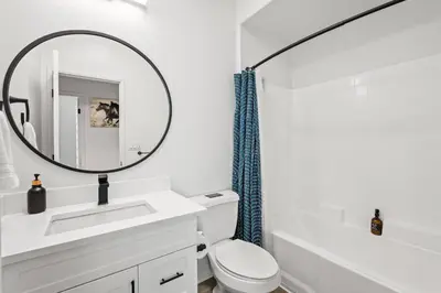 a white bathroom with a sink and a mirror at Cozy 3 BR Apartment | Near Disney in Placentia