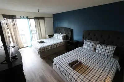 a bedroom with two beds and a blue wall at Private Apt with Queen bed in great neighborhood in Los Angeles