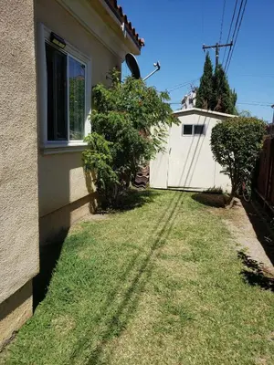 a yard next to a house with a fence at Spacious home near LAX in Hawthorne
