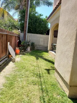 a backyard with a fence and a yard withgrass at Spacious home near LAX in Hawthorne