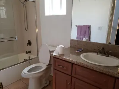 a bathroom with a toilet and a sink and a mirror at Spacious home near LAX in Hawthorne