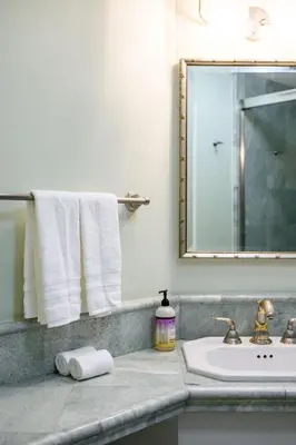 a bathroom with a sink and a mirror and towels at Airy Large Backyard Oasis Perfect Family Getaway in Tustin