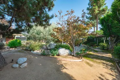 a garden with rocks and trees and a driveway at Airy Large Backyard Oasis Perfect Family Getaway in Tustin