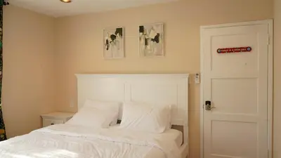 a bed with white sheets and pillows in a bedroom at Entire house with 3 rooms in Alhambra