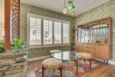 a dining room with a glass table and stools at Stunning MCM Escape with Mtn Views in San Bernardino in San Bernardino