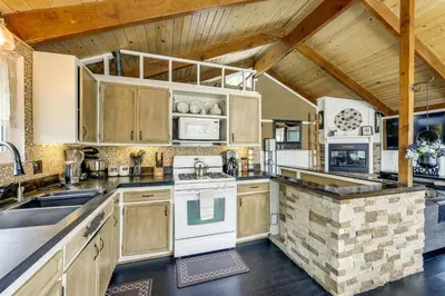 a kitchen with white appliances and a wooden ceiling at 2 Mi to Lake Arrowhead! Mtn-View Hideaway with Deck in Cedar Glen