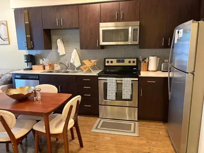 a kitchen with a table and a stainless steel refrigerator at Luxurious precious mile in Los Angeles
