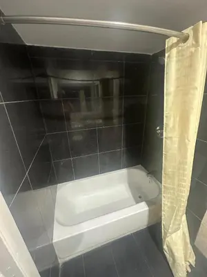 a white bath tub in a bathroom with a shower curtain at Heritage Inn in Pomona