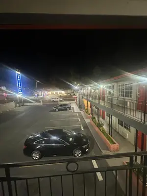 a black car parked in a parking lot at night at Heritage Inn in Pomona