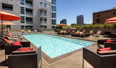 a swimming pool with chairs and umbrellas on a building at DTLA prime one bedroom steps away from Crypto in Los Angeles
