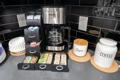 a counter with a coffee maker and two cups at Disney Frozen Fantasy by OC Adventure Homes in Garden Grove