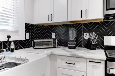 a kitchen with white cabinets and a toaster oven at Disney Frozen Fantasy by OC Adventure Homes in Garden Grove