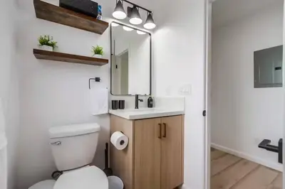 a bathroom with a toilet and a sink and a mirror at Disney Frozen Fantasy by OC Adventure Homes in Garden Grove