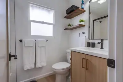 a bathroom with a toilet and a sink and a window at Disney Frozen Fantasy by OC Adventure Homes in Garden Grove