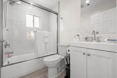 a white bathroom with a toilet and a shower at Niagara Haven Unit 103 in Burbank