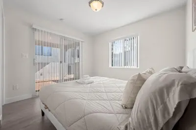 a white bedroom with a bed and a window at Niagara Haven Unit 103 in Burbank