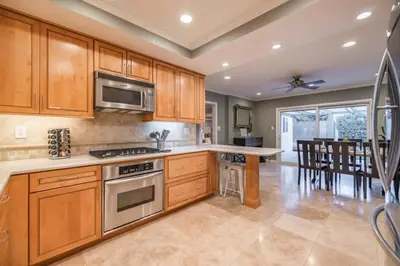 a kitchen with wooden cabinets and a stove top oven at Marbella Lane - Charming 4BR Bungalo for Relaxing Retreat in Fullerton