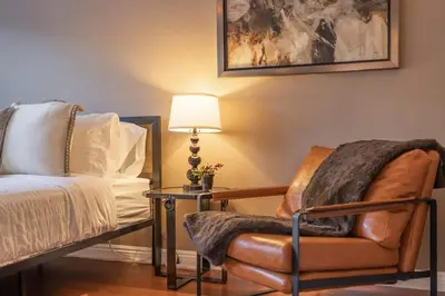 a bedroom with a bed and a chair and a lamp at Marbella Lane - Charming 4BR Bungalo for Relaxing Retreat in Fullerton