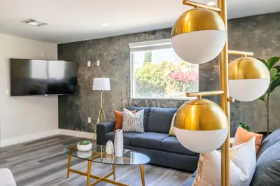 a living room with a blue couch and gold accents at Modern 4BR Stay Premium Beds & Full Kitchen in Burbank