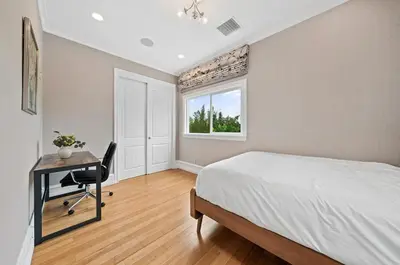 a bedroom with a bed and a desk and a window at Modern Luxe Villa Pool Rooftop Paradise in Sherman Oaks