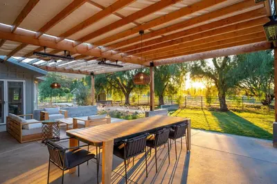 a patio with a wooden table and chairs at Ojai Valley - Pool and Pickle Ball in Ojai