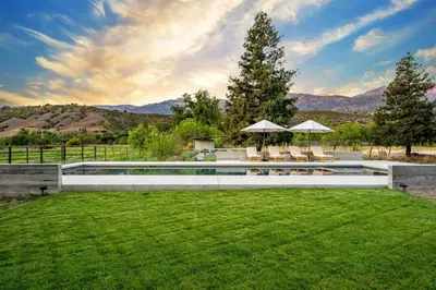 a pool in a yard with chairs and umbrellas at Ojai Valley - Pool and Pickle Ball in Ojai