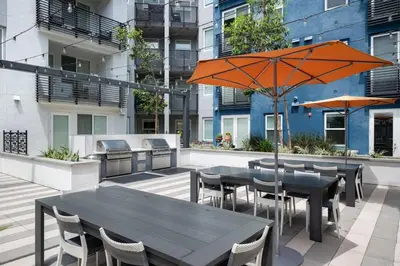 a patio with tables and chairs and an umbrella at The Mandarin at Main Place - Free Disney Gift Gard in Orange