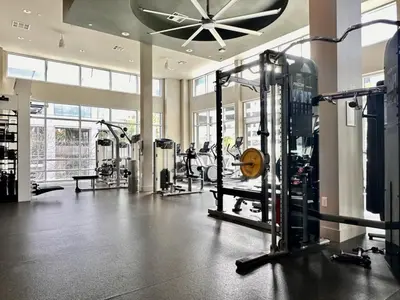 a gym with several machines and a ceiling fan at Casa Clementine - 10 min to SNA&Beach Plus Free Parking in Orange