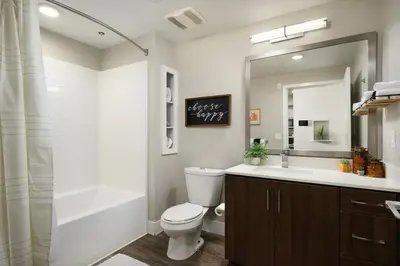 a bathroom with a toilet and a tub and a sink at The Belladonna at Main Place - Disney Gift Card! in Orange