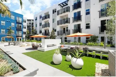 an apartment patio with tables and chairs and plants at The Belladonna at Main Place - Disney Gift Card! in Orange