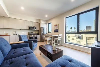 a living room with a couch and a table at Luxury 1BD Condo in LA with Rooftop City Views, Gym & Free Parking in Los Angeles