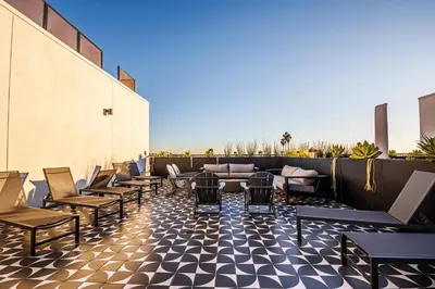 a row of chairs and tables on a rooftop patio at Luxury 1BD Condo in LA with Rooftop City Views, Gym & Free Parking in Los Angeles