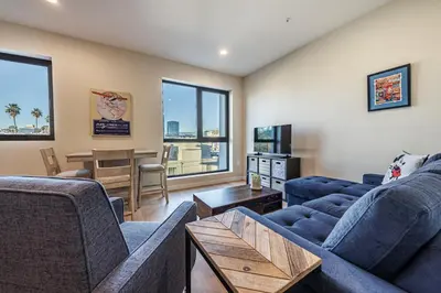 a living room with two blue couches and a table at Luxury 1BD Condo in LA with Rooftop City Views, Gym & Free Parking in Los Angeles