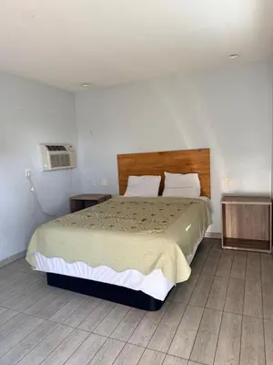a bedroom with a large bed and a fan at Casa Motel in Los Angeles